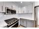 Updated kitchen features stainless steel microwave, range, white subway tile, and modern finishes at 11028 Meadow Leaf Ave, Las Vegas, NV 89144