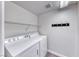 Functional laundry area equipped with a washer, dryer, and shelving at 11028 Meadow Leaf Ave, Las Vegas, NV 89144