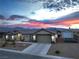 Exterior view of a single-story home with a large garage on a desert landscape at 111 Magnolia Blvd, Pahrump, NV 89048