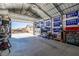 Inside of spacious garage with work area, storage, concrete flooring, and large garage door at 111 Magnolia Blvd, Pahrump, NV 89048