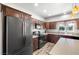 Modern kitchen featuring dark wood cabinets, a large refrigerator, and sleek black appliances at 111 Magnolia Blvd, Pahrump, NV 89048