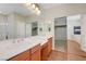 Bathroom featuring double sinks, wood cabinets, and closet at 11444 Steponia Bay St, Las Vegas, NV 89141