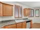 Kitchen sink with wood cabinets, stainless steel dishwasher, and granite countertops at 11444 Steponia Bay St, Las Vegas, NV 89141