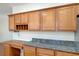 Kitchen counter and desk area with wood cabinets and granite countertops at 11444 Steponia Bay St, Las Vegas, NV 89141
