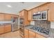 Well-equipped kitchen with stainless steel appliances, granite countertops, and wood cabinetry at 11444 Steponia Bay St, Las Vegas, NV 89141