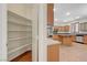 Walk-in pantry leading to kitchen with island and stainless steel appliances at 11444 Steponia Bay St, Las Vegas, NV 89141