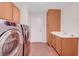 Functional laundry room with washer, dryer, utility sink, and ample storage cabinets at 11444 Steponia Bay St, Las Vegas, NV 89141