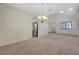 Open-concept living room with high ceiling, chandelier, and view to kitchen area at 11444 Steponia Bay St, Las Vegas, NV 89141