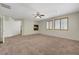 Open living room with fireplace, neutral walls, ceiling fan, and a fireplace at 11444 Steponia Bay St, Las Vegas, NV 89141