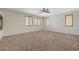 Large carpeted primary bedroom featuring plantation shutters and a ceiling fan at 11444 Steponia Bay St, Las Vegas, NV 89141