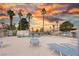 Community pool with lounge chairs under a vibrant sky at sunset at 1300 Pinto Rock Ln # 201, Las Vegas, NV 89128