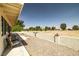 A spacious backyard with a low wall, gravel, a small patch of grass, and views of the desert and mountains at 1320 Daytona St, Pahrump, NV 89048