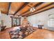 Living room featuring a rustic fireplace, Saltillo floors, and a beamed ceiling at 1320 Daytona St, Pahrump, NV 89048