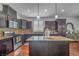 Modern kitchen with stainless steel appliances, granite countertops, and dark wood cabinetry at 153 Via Di Mello, Henderson, NV 89011