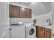 Well-lit laundry room with modern washer and dryer, cabinets, sink and faucet at 153 Via Di Mello, Henderson, NV 89011