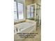 Luxurious main bath with a soaking tub and a glass-enclosed shower featuring elegant tile accents and finishes at 153 Via Di Mello, Henderson, NV 89011
