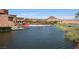 Picturesque view of a lake with a beach, golf cart, and resort in the background, creating a serene and inviting atmosphere at 153 Via Di Mello, Henderson, NV 89011