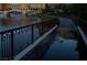 Inviting waterfront pathway with ornate iron railings, reflecting the surrounding buildings in a calm puddle, creating a tranquil scene at 153 Via Di Mello, Henderson, NV 89011