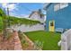 Side yard with artificial turf features a white metal bench next to a yellow door at 1601 Eaton Dr, Las Vegas, NV 89102