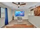 This airy bonus room includes wood floors, a large TV, and a ceiling fan at 1601 Eaton Dr, Las Vegas, NV 89102