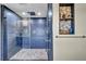 Modern shower with blue tile, dual shower heads, glass doors, and a decorative niche at 1601 Eaton Dr, Las Vegas, NV 89102