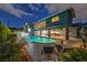 Beautiful swimming pool at night with mature landscaping, adjacent to the covered patio at 1601 Eaton Dr, Las Vegas, NV 89102