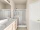 Bathroom with double sinks, neutral tile flooring and glass shower at 199 Bailey Island Dr, Henderson, NV 89074