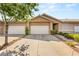A well-maintained townhome with a two-car garage and neatly landscaped yard is pictured on a sunny day at 199 Bailey Island Dr, Henderson, NV 89074
