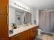 Bright bathroom featuring a large mirror, wood cabinets, and a shower/tub combo at 200 W Sahara Ave # 1703, Las Vegas, NV 89102