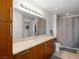 Bathroom featuring wood cabinets, modern fixtures, a large mirror, and shower at 200 W Sahara Ave # 1703, Las Vegas, NV 89102