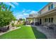 Expansive backyard showcasing a covered patio, waterfall feature, and a well-maintained lawn at 205 Piedmont Alps St, Henderson, NV 89012