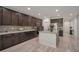 Modern kitchen with granite countertops, dark cabinets, a kitchen island, and stainless steel appliances at 205 Piedmont Alps St, Henderson, NV 89012