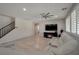 A bright living room with a fireplace, white leather couch, and a ceiling fan at 205 Piedmont Alps St, Henderson, NV 89012