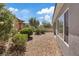 Landscaped backyard featuring gravel, trimmed bushes, and partial views of a one-story home at 2108 Willow Wren Dr, North Las Vegas, NV 89084