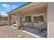 Covered patio area with a table and chairs, surrounded by gravel landscaping and views into the home at 2108 Willow Wren Dr, North Las Vegas, NV 89084