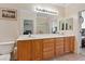 Bright bathroom with a large mirror above wooden cabinets, featuring dual sinks and tile flooring at 2108 Willow Wren Dr, North Las Vegas, NV 89084