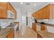 Galley kitchen with oak cabinets, granite countertops, white appliances, and tile floors at 2108 Willow Wren Dr, North Las Vegas, NV 89084