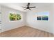 Bright bedroom featuring wood floors, ceiling fan, and dual windows at 2180 Palora Ave, Las Vegas, NV 89169