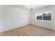 Bedroom with modern lighting, hardwood floors, and a large window overlooking the yard at 2180 Palora Ave, Las Vegas, NV 89169