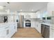 Gourmet kitchen with white cabinets, island, stainless steel appliances, and modern finishes at 2180 Palora Ave, Las Vegas, NV 89169