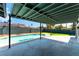 Covered patio overlooking a refreshing pool and artificial turf lawn, ideal for outdoor living and entertaining at 2180 Palora Ave, Las Vegas, NV 89169