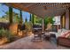 Inviting backyard retreat with a covered patio, stylish seating, hot tub, and lush landscaping for relaxation at 2435 Granada Bluff Ct, Las Vegas, NV 89135