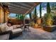 Serene backyard showcasing a covered patio, comfortable seating, mature trees, and charming outdoor decor at 2435 Granada Bluff Ct, Las Vegas, NV 89135