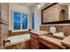 Luxurious bathroom with a soaking tub, dual sinks, and tiled walls at 2435 Granada Bluff Ct, Las Vegas, NV 89135