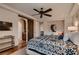 Spacious bedroom with a patterned bedspread, ceiling fan, and sliding barn door to the bath at 2435 Granada Bluff Ct, Las Vegas, NV 89135