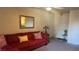 Cozy living room featuring a red sofa, decorative pillows, an ornate mirror, and a ceiling fan at 2606 S Durango Dr # 263, Las Vegas, NV 89117