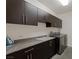 Functional laundry room with granite countertops, modern cabinets, and stainless steel appliances at 2672 Mystere Ct, Las Vegas, NV 89117