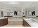 Bathroom featuring a soaking tub with marble surround, dual sinks, and mirrored walls at 2777 Paradise Rd # 1105, Las Vegas, NV 89109