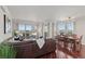 Open-concept living room with a brown leather couch, dining area, and expansive windows showcasing the cityscape at 2777 Paradise Rd # 1105, Las Vegas, NV 89109