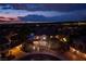 Aerial shot showcasing the home, neighborhood, and city lights in the background at dusk at 2900 Valvent Ct, Henderson, NV 89044